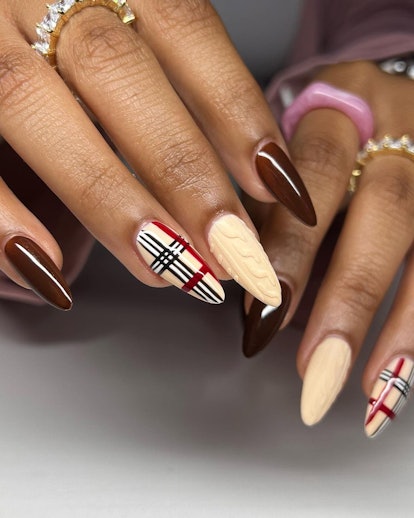 A fall nail art design with dark red nail polish, sweater nail art, and a plaid accent nail.