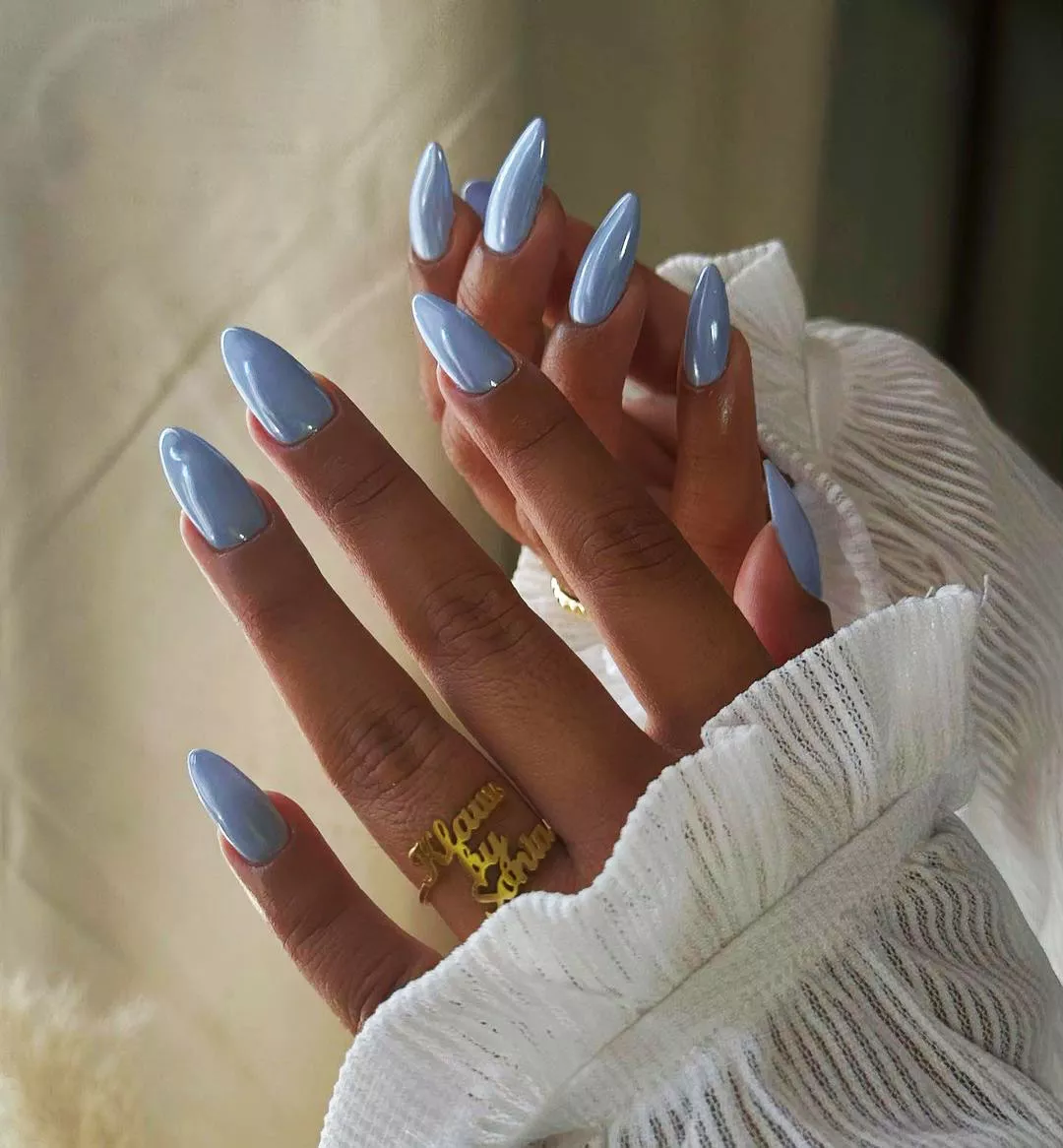 A woman wearing a baby blue chrome nail design