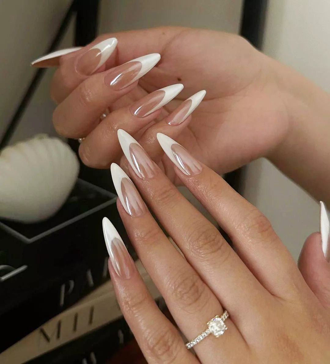 A woman wearing a french tip chrome nail design