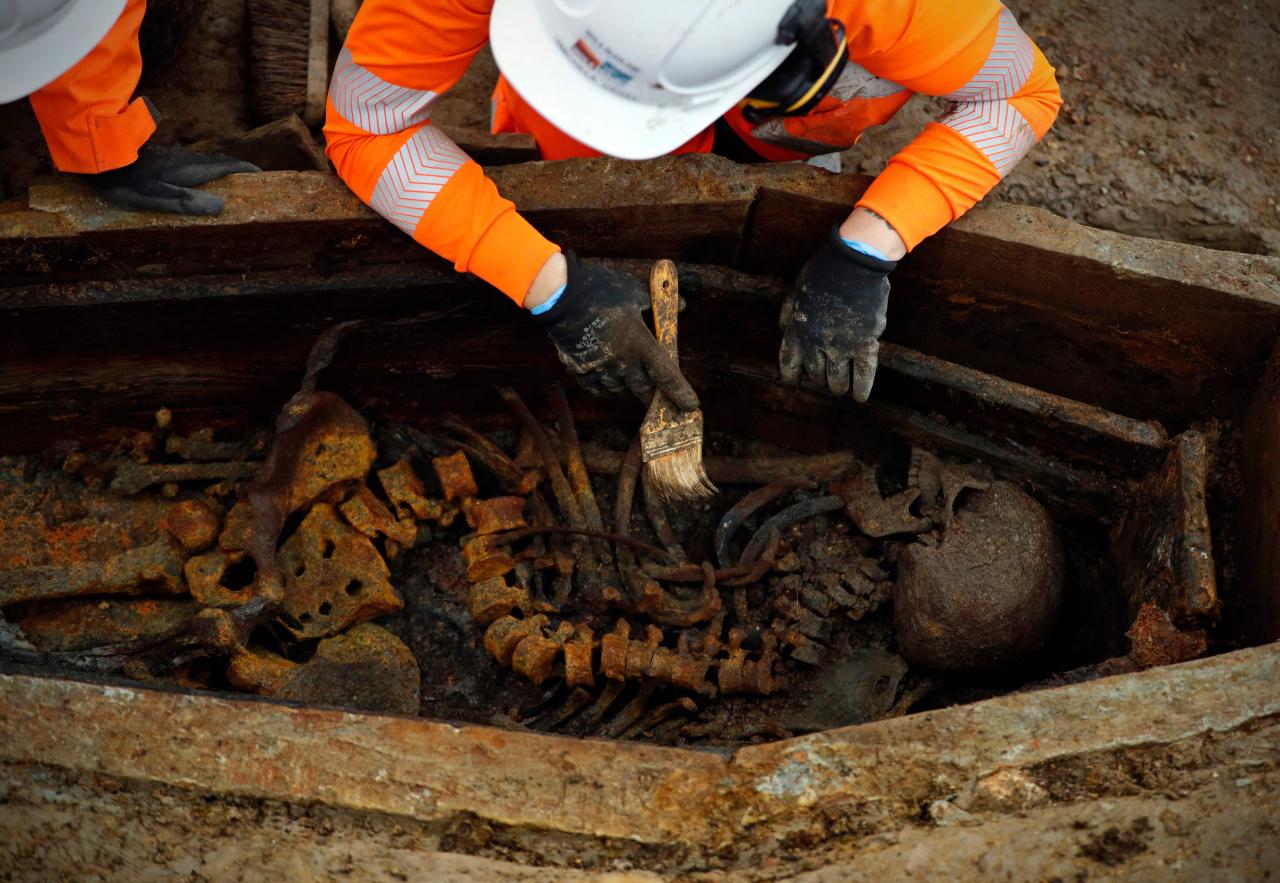  An archaeologist brushes away dirt from the exposed skeleton - one of an estimated 60,000 at St James's Gardens