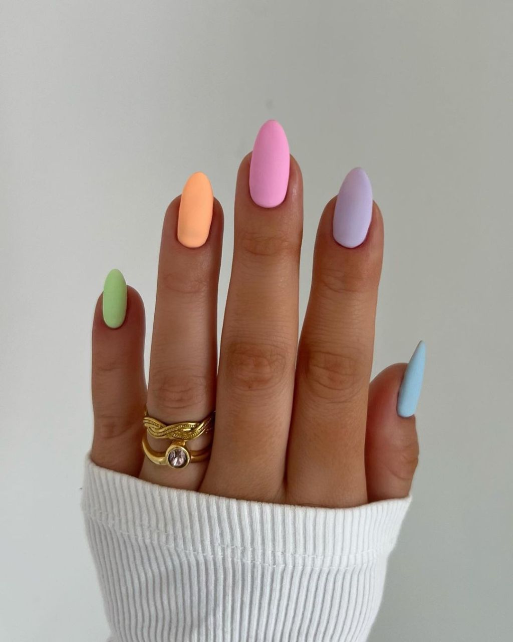 matte simple almond shaped spring nails with a skittle design using pastel green, orange, pink, purple, and blue colors