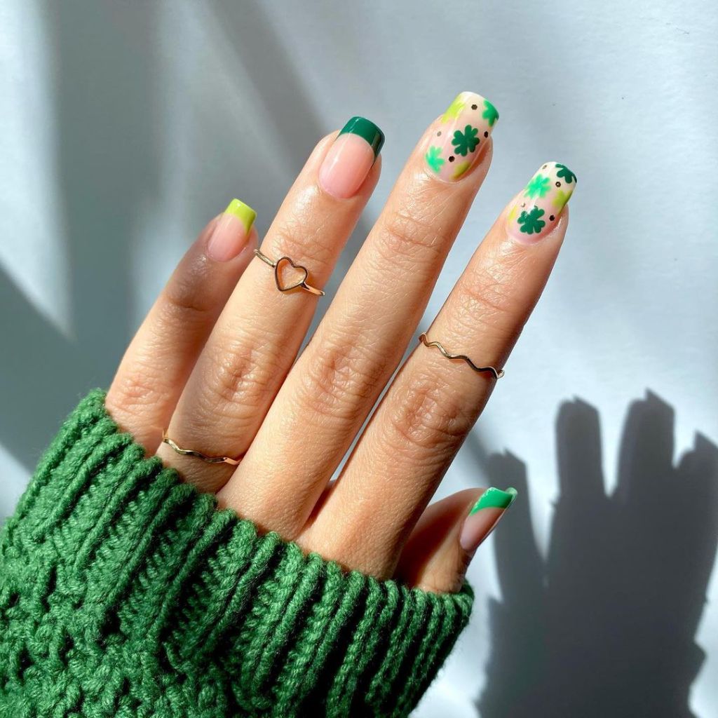 cute green French tip St Patricks Day nails with shamrock nail art on the pointer and middle fingers