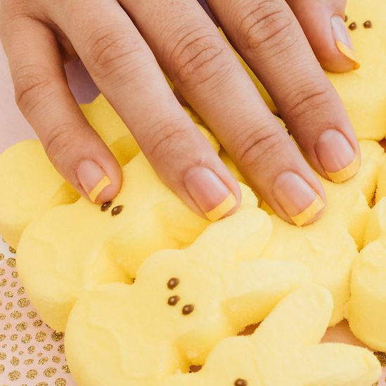 a manicured hand resting atop yellow peeps marshmallow treats