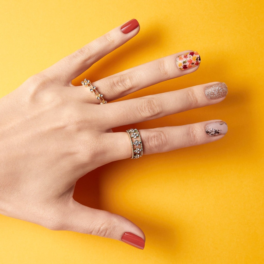 short sparkly falling leaves themed cute Thanksgiving nails ideas with warm orange and brown hues and a gold accented design