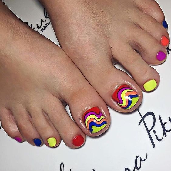 Colorful nail colors and swirls on short toe nails