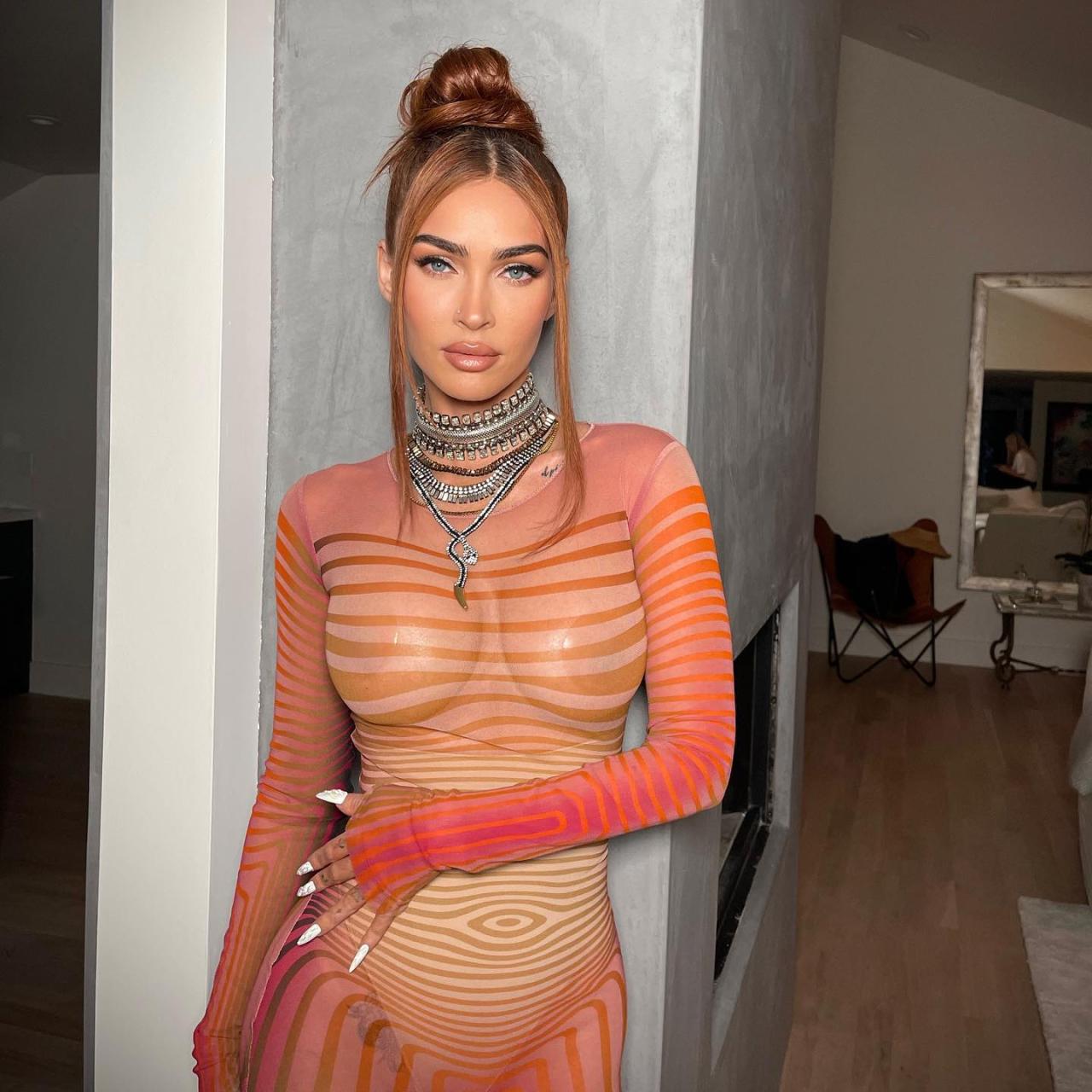 Mgena Fox has shown off her curves while posing in a sheer orange dress