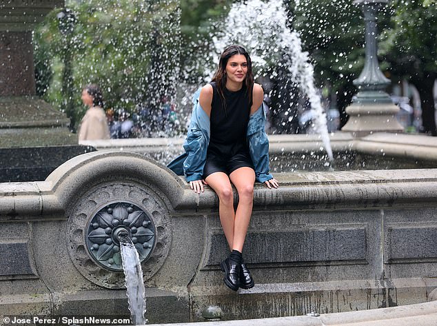 Committed to her art: The beauty then climbed out and continued to pose with her clothes dripping wet