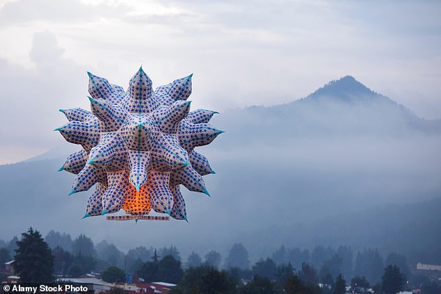 A large sky lantern floats towards a mountain outside of Paracho, a city in the western Mexican state of Michoacán, during the annual Globos de Cantoya festival