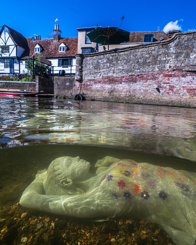 Furious homeowners in a picturesque English town have been left outraged after a 'distasteful' underwater sculpture was confused for a drowned woman