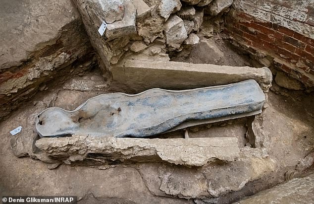 The coffin found under Notre-Dame cathedral after the devastating 2019 fire has been identified as belonging to 16th century Frenchman Joachim du Bellay. Pictured, the lead sarcophagus of the previously 'unknown' individual surrounded by 19th century heating flues