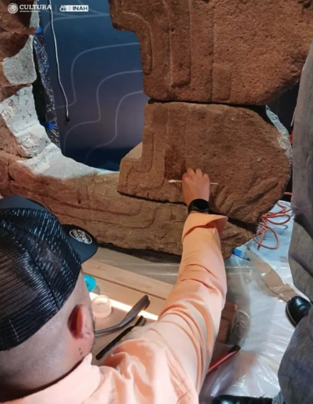 Excavators clean the sculpture following its return