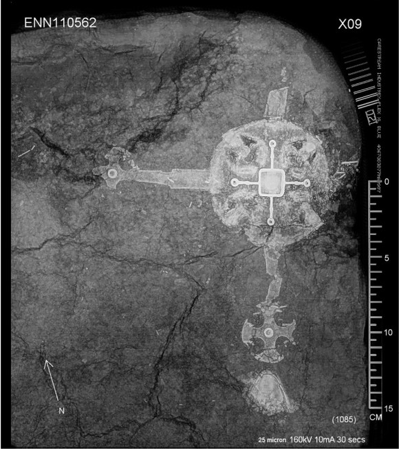 left X-ray analysis of a soil block taken from the grave revealed the presence of a large and ornate cross within it. above The cross was decorated with small silver faces with blue glᴀss eyes.