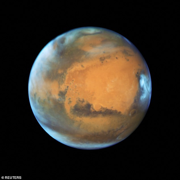 The ice sheets that might hold life on Mars were formed by dusty snow storms over the course of dozens of ice ages that hit the Red Planet across the past 5 million years. Above: a May 12, 2016 NASA image taken with the Hubble Space Telescope showing Mars' visible cloud cover