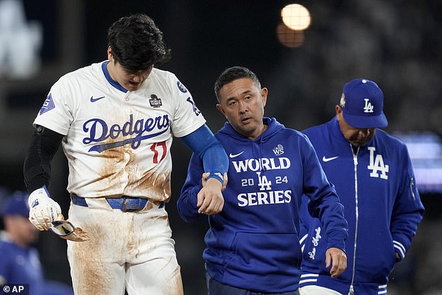 Ohtani walked toward the dugout with Dodgers ᴀssistant athletic trainer Yosuke Nakajima