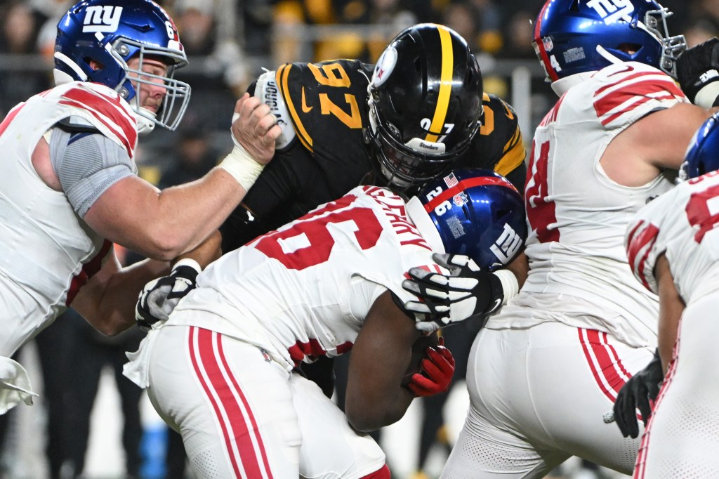 Pittsburgh Steelers defensive tackle Cameron Heyward (97) tackles New York Giants running back Devin Singletary (26) during the third quarter at Acrisure Stadium. 