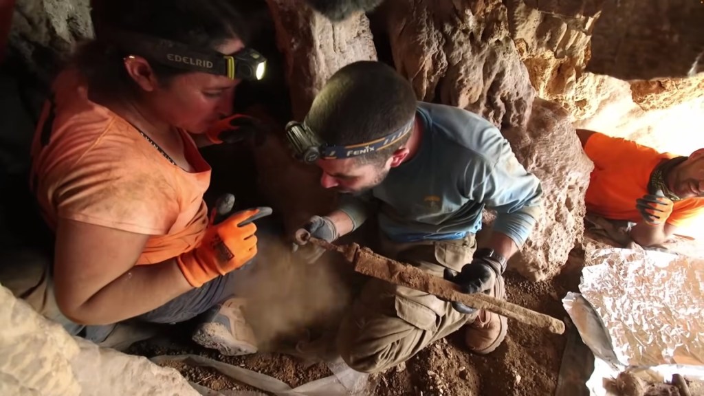 Researchers seen handling one of the ancient swords in the cave