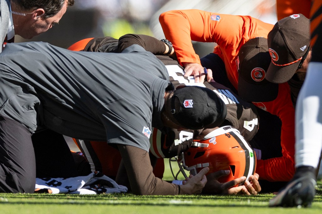 Browns quarterback Deshaun Watson (4) is attended to by head coach Kevin Stefanski and team medical personnel for his torn Achilles during the second quarter against the Cincinnati Bengals at Huntington Bank Field. 