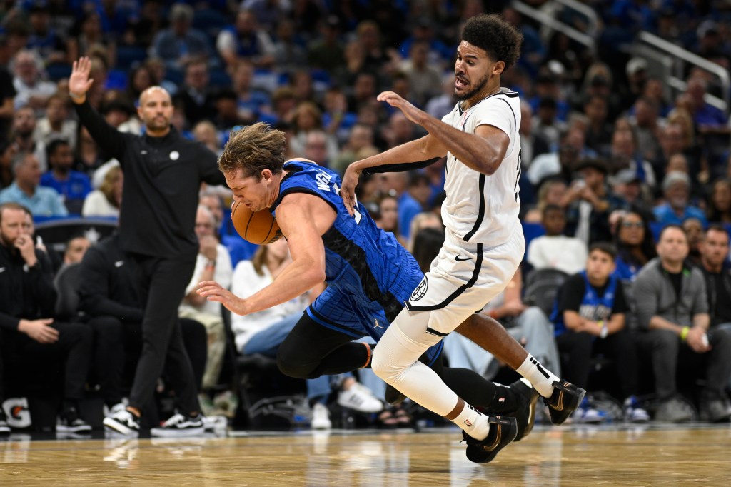 Magic center Moritz Wagner is fouled by Brooklyn Nets forward Cameron Johnson, right, while driving to the basket during the second half of an NBA basketball game, Friday, Oct. 25, 2024.