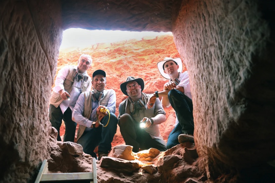 Archaeology researchers Dr. Fares Braizat, Fadi Balawi, Josh Gates, and Dr. Pearce Paul Creasman uncovering a hidden tomb under Petra's iconic treasury