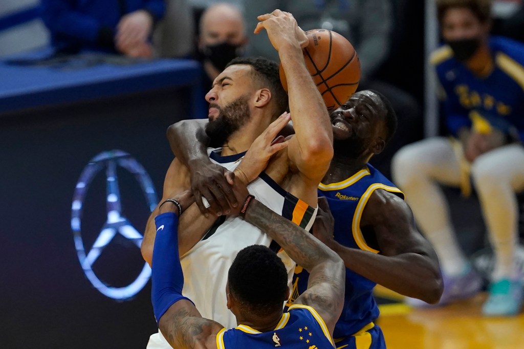 Draymond Green (right) put Rudy Gobert (center) in a headlock during a contest during the 2023-24 season.