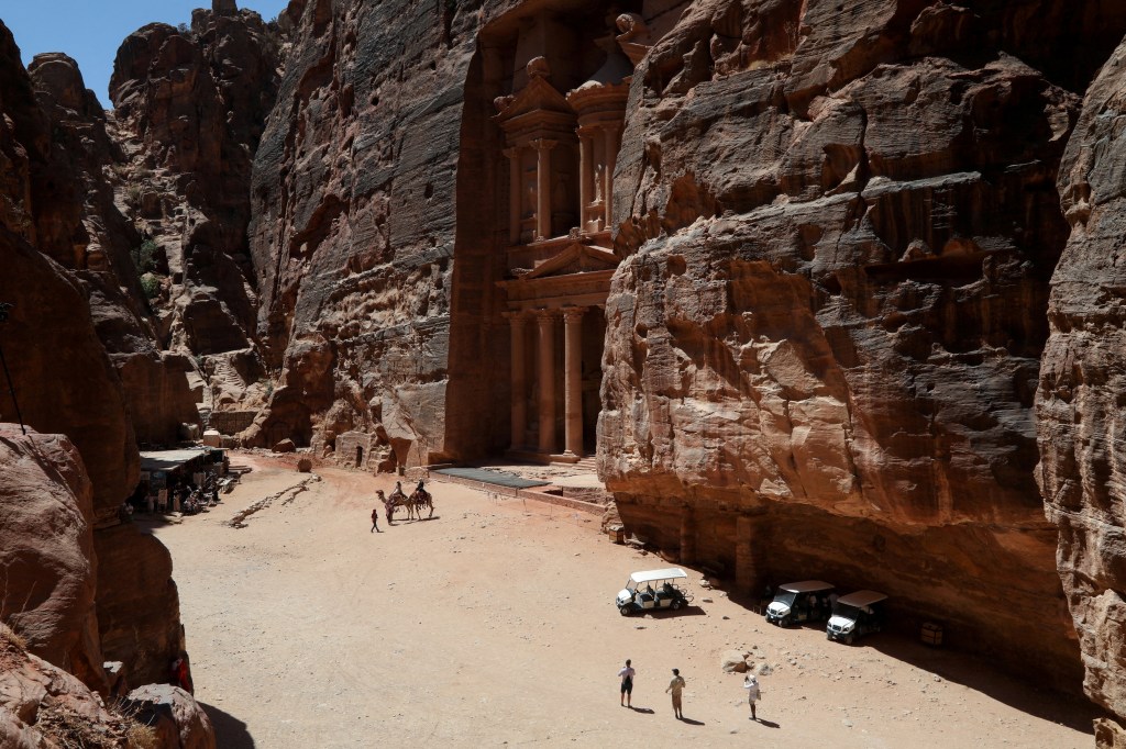 A few visitors standing in front of the Treasury site in the ancient city of Petra, Jordan on August 25, 2024