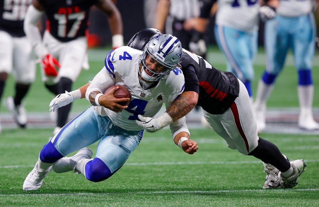 Dak Prescott of the Cowboys is tackled by Nate Landman of the Atlanta Falcons during the third quarter at Mercedes-Benz Stadium on November 3, 2024.