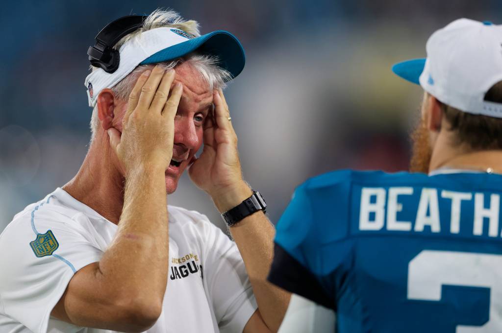 Jacksonville Jaguars quarterbacks coach Mike McCoy mᴀssages his face while talking with quarterback C.J. Beathard (3) during the fourth quarter of a preseason NFL football game