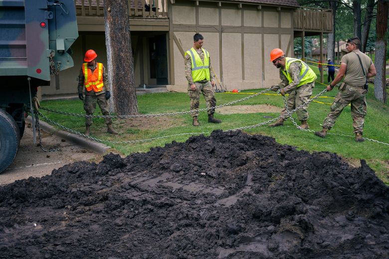 In this handout pH๏τo from the New Mexico National Guard, members of the New Mexico National guard work on flooding damage Saturday, June 29, 2024, in Ruidoso, N.M. Thunderstorms are hopscotching around the Southwestern U.S., bringing much-needed moisture to a region where every drop counts. (Spc. Jose Montoya/New Mexico National Guard via AP)