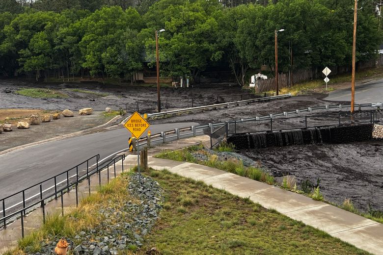 In this handout pH๏τo from the New Mexico National Guard, floodwater flows over a bridge Saturday, June 29, 2024, in Ruidoso, N.M. Thunderstorms are hopscotching around the Southwestern U.S., bringing much-needed moisture to a region where every drop counts. (Spc. Jose Montoya/New Mexico National Guard via AP)